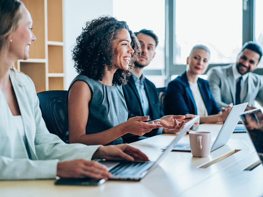 Corporate staff seated at a conference table discussing a topic