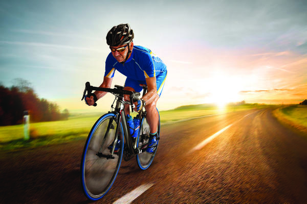 A man riding a bike down an empty road.